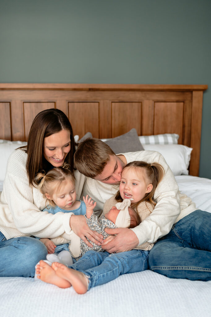 mom, dad and their three kiddos in bed