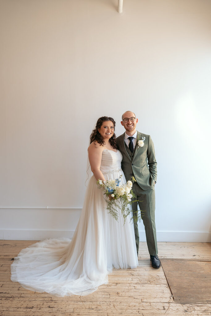 bride and groom in front of a white wall at the neu neu wedding venue