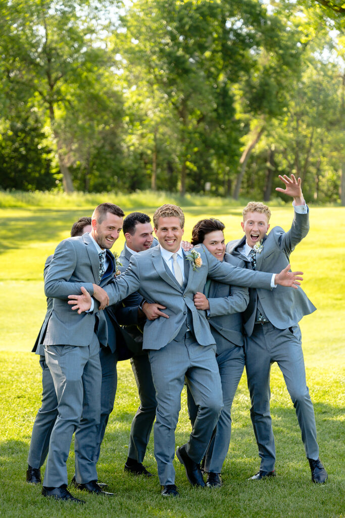 bride and groom and their wedding party on the golf course during the bemidji country club wedding day