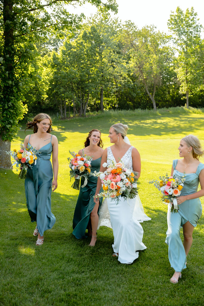 bride and groom and their wedding party on the golf course during the bemidji country club wedding day
