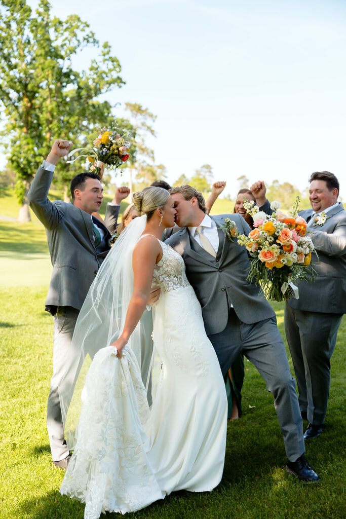 bride and groom and their wedding party on the golf course during the bemidji country club wedding day