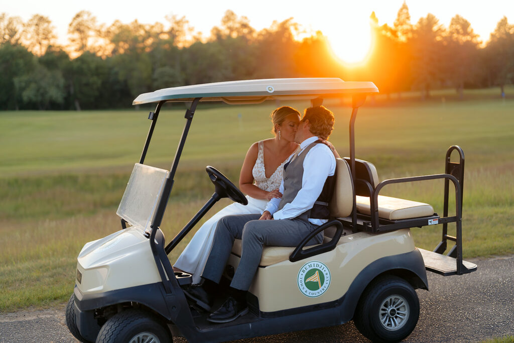 bride and groom riding in a golf cart