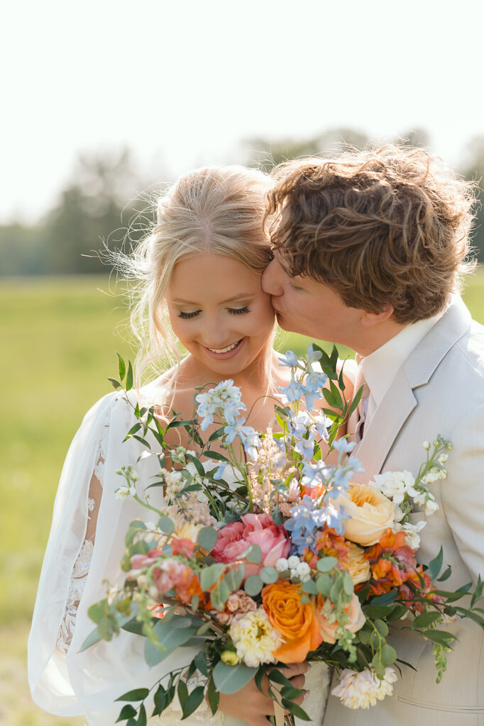 dreamy bride and groom moments in a lush green field during a spring wedding at bluebelle event venue