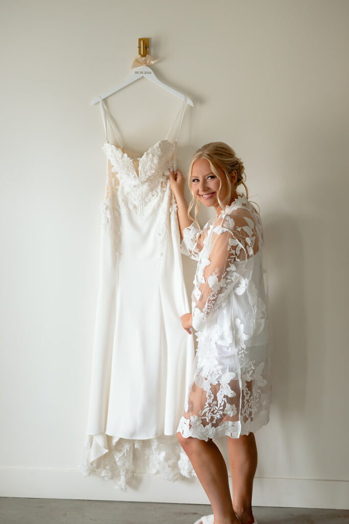 bride next to her wedding dress