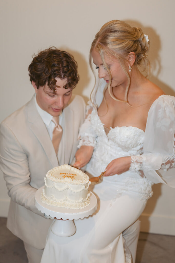 bride and groom cutting a small vintage cake