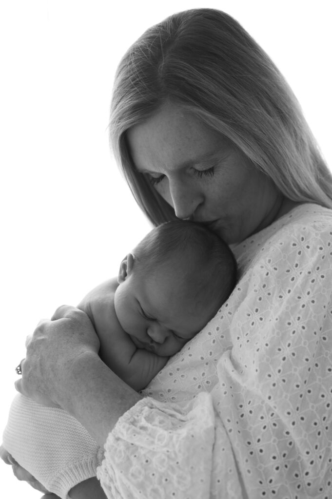 mom and newborn next to a window at the sunroom studio in bemidji mn