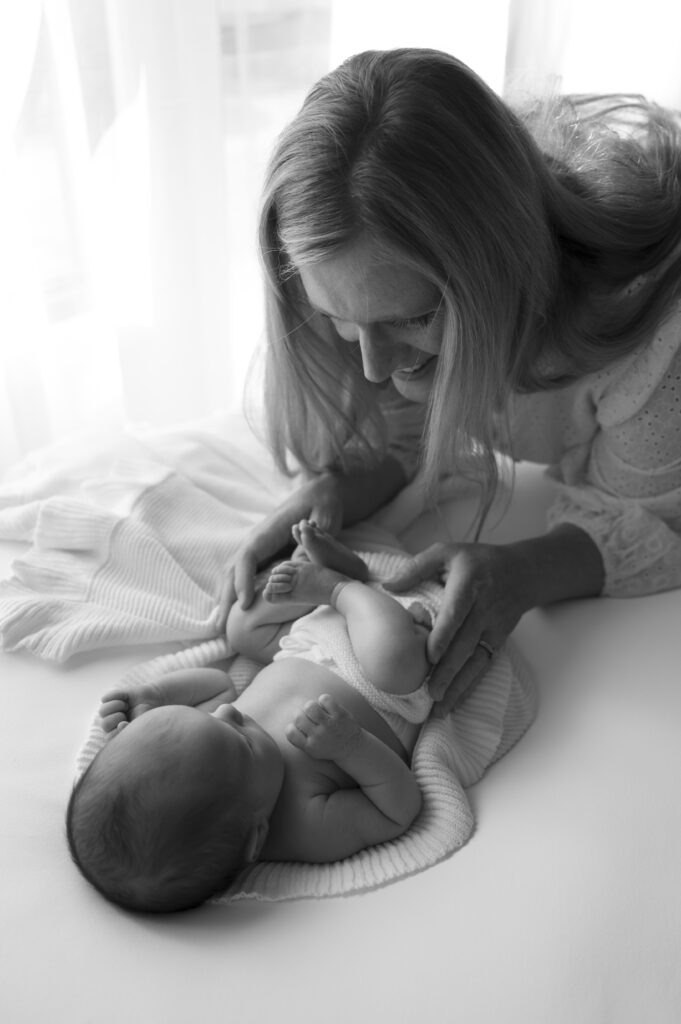 mom and newborn next to a window at the sunroom studio in bemidji mn