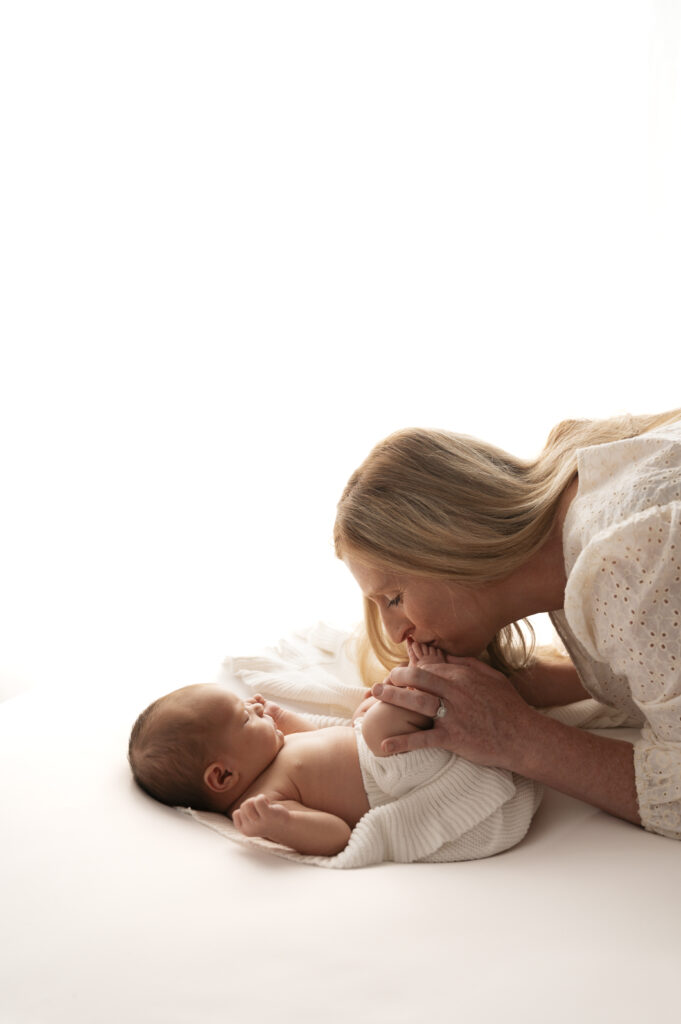 mom and newborn next to a window at the sunroom studio in bemidji mn