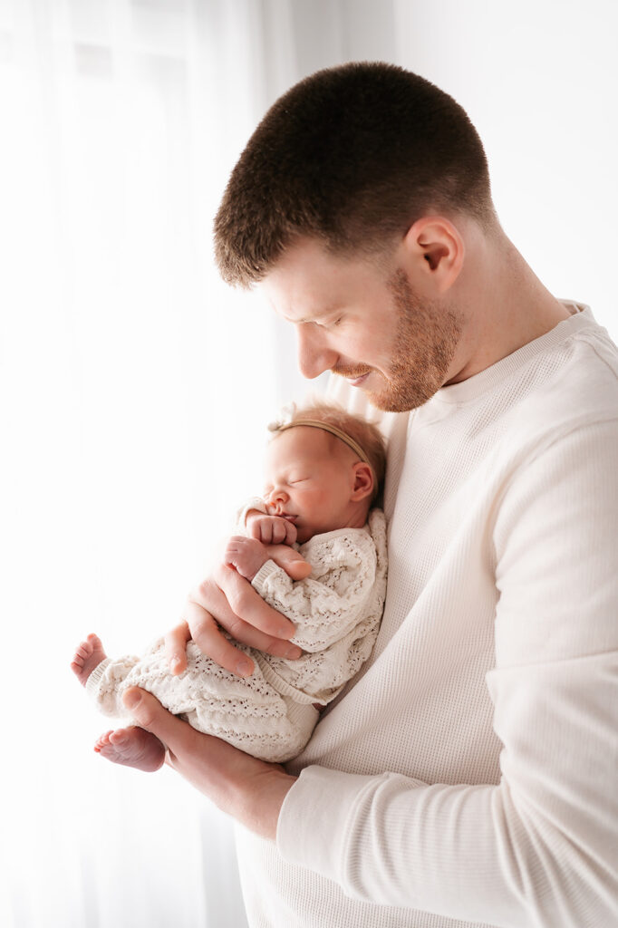 dad and newborn baby in a light timeless studio in bemidji mn