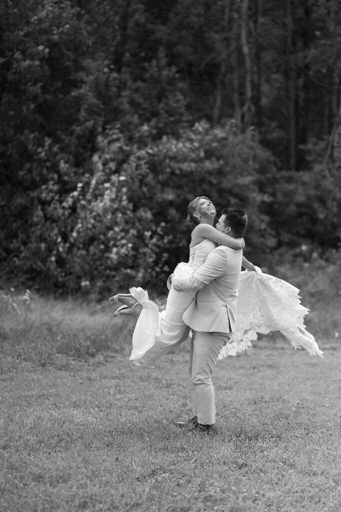 playful bride and groom in a lush field during golden hour at the bluebelle event venue