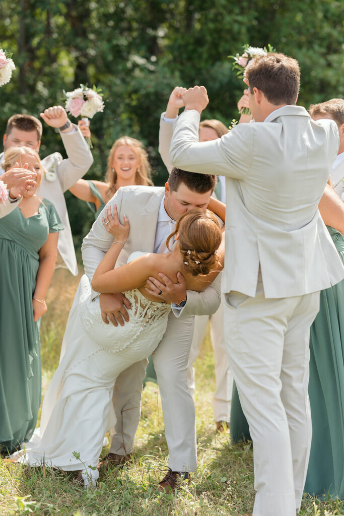 bride and groom surrounded by cheering wedding party