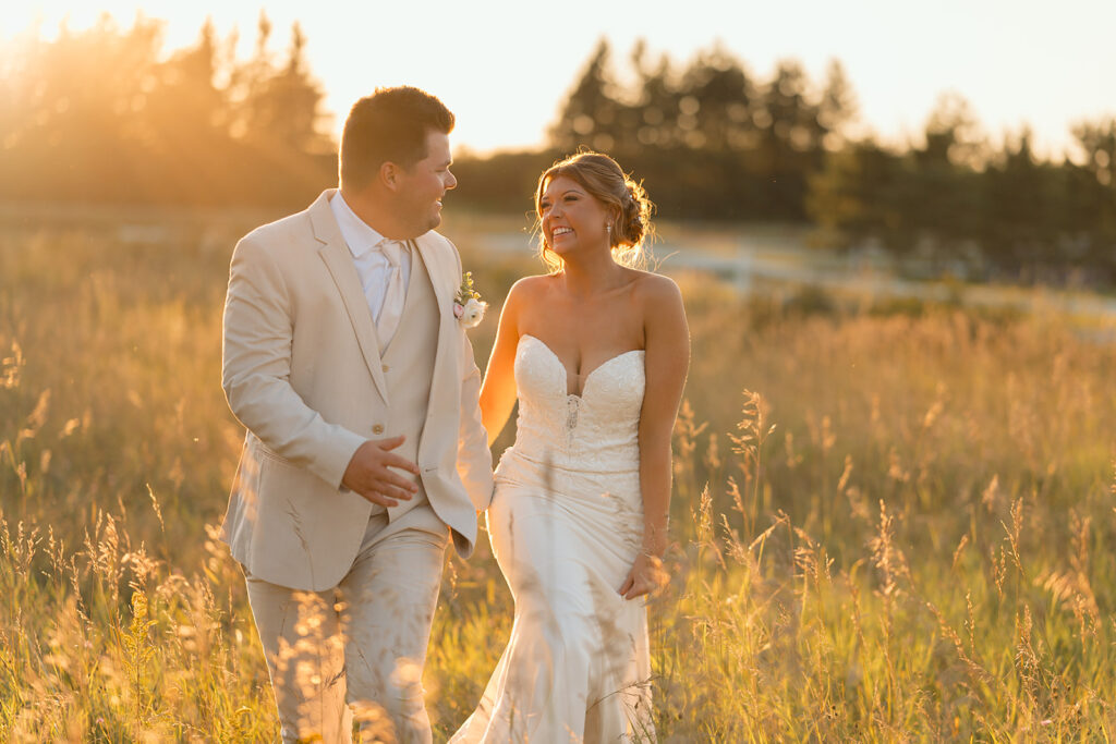 bride and groom in a lush field during golden hour at the bluebelle event venue