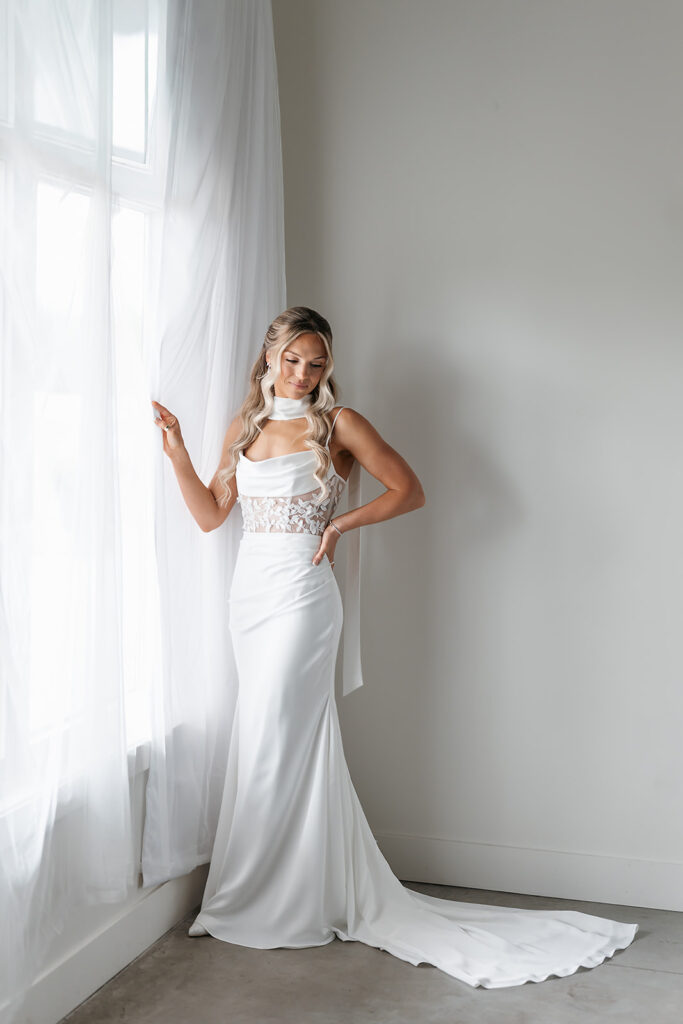 bridal portrait next to a large window inside the bluebelle event venue