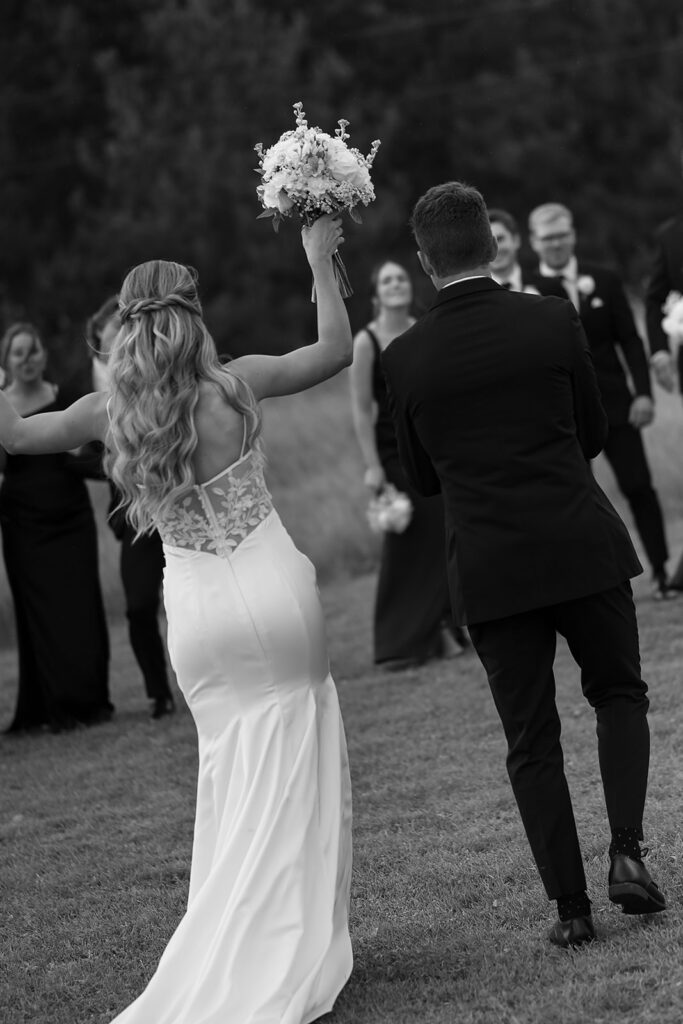 bride and groom and wedding party are cheering