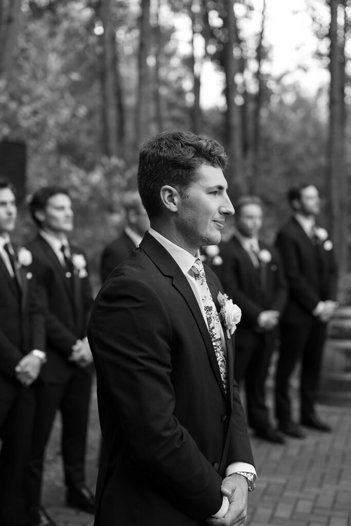 groom waiting at the end of the aisle during the outdoor wedding ceremony at the bluebelle event venue