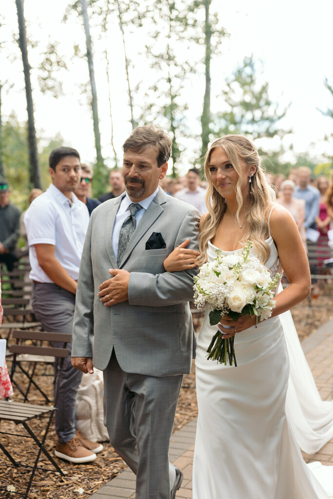 dad walking bride down the aisle during the outdoor wedding ceremony at the bluebelle event venue