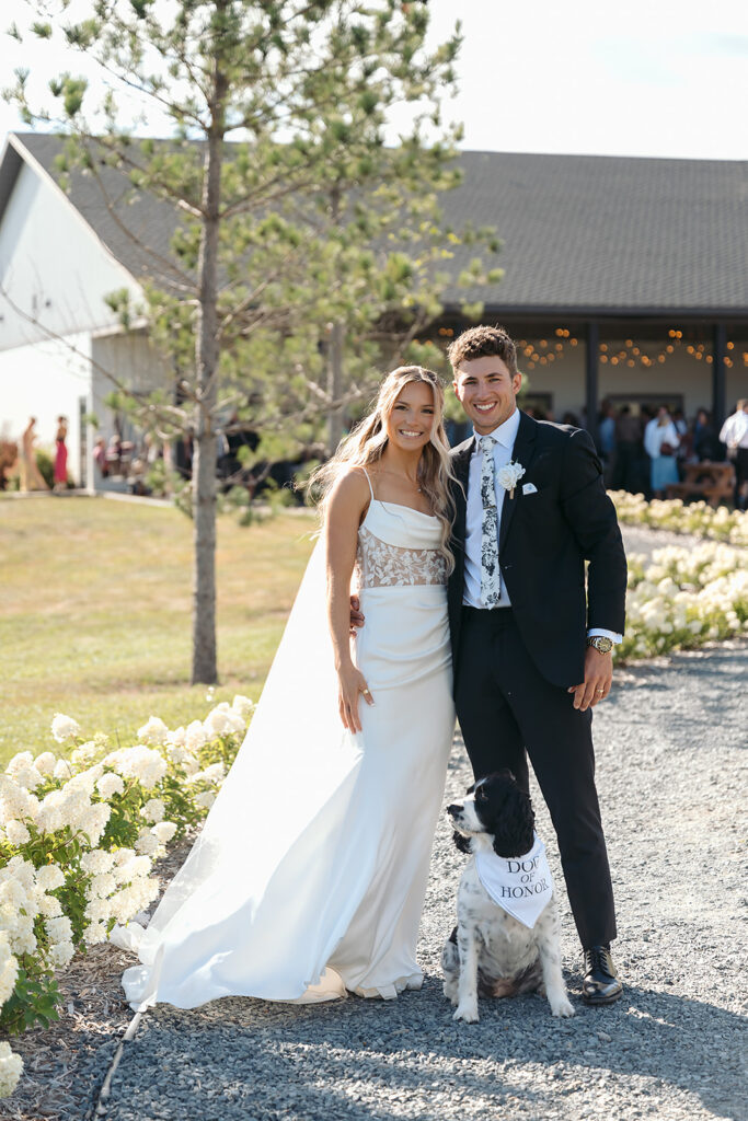 bride and groom posing with their dog of honor