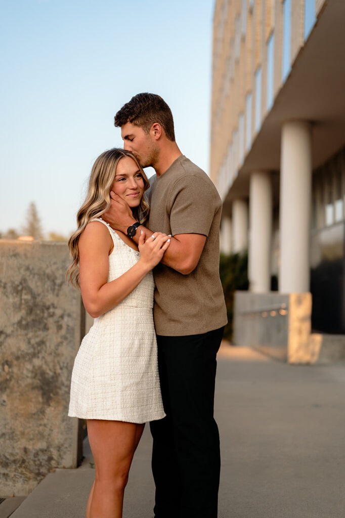 sweet couple hugging during golden hour for their downtown engagement photos in Bemidji