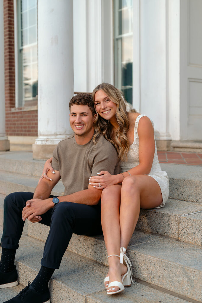 sweet couple sitting on steps during golden hour for their downtown engagement photos in Bemidji