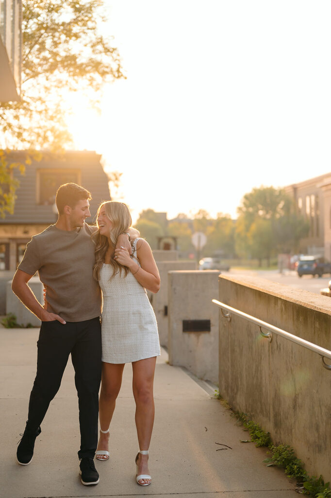 sweet couple walking around during golden hour for their downtown engagement photos in Bemidji