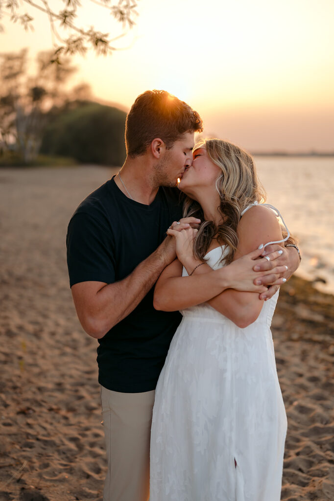 couple being sweet and playful during sunset on Lake Bemidji shore