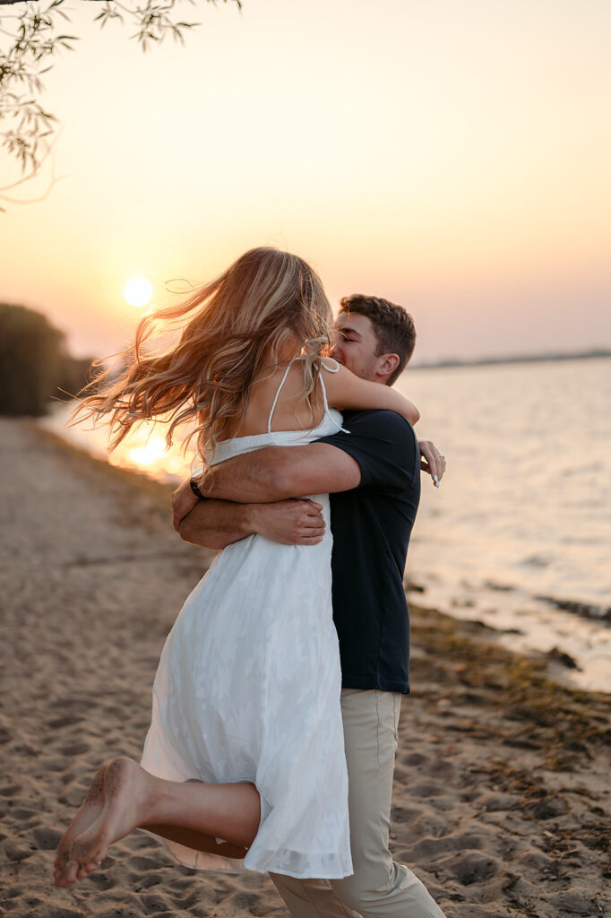 couple being sweet and playful during sunset on Lake Bemidji shore