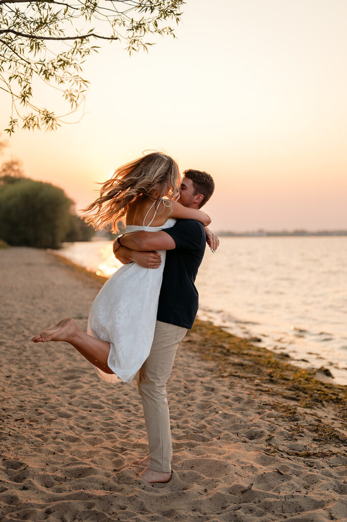 couple being sweet and playful during sunset on Lake Bemidji shore