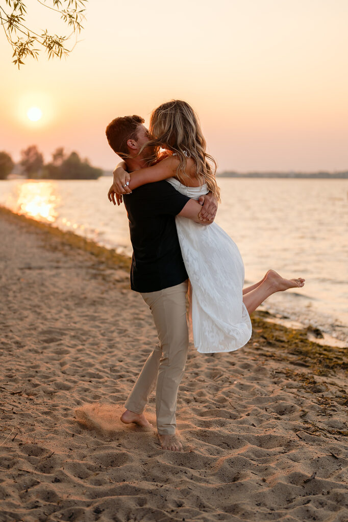 couple being sweet and playful during sunset on Lake Bemidji shore