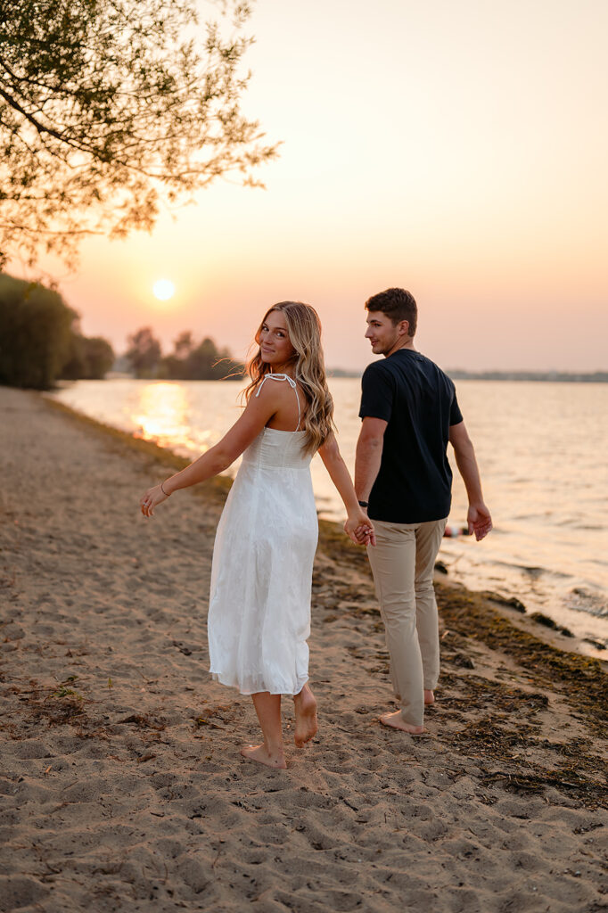 couple being sweet and playful during sunset on Lake Bemidji shore