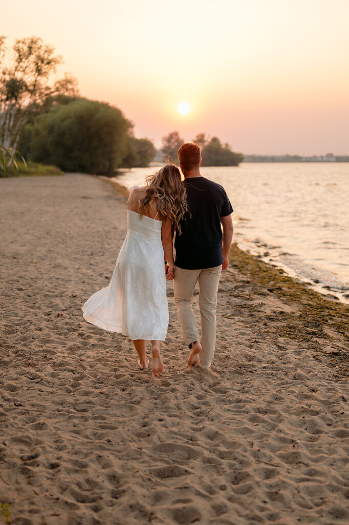 couple being sweet and playful during sunset on Lake Bemidji shore