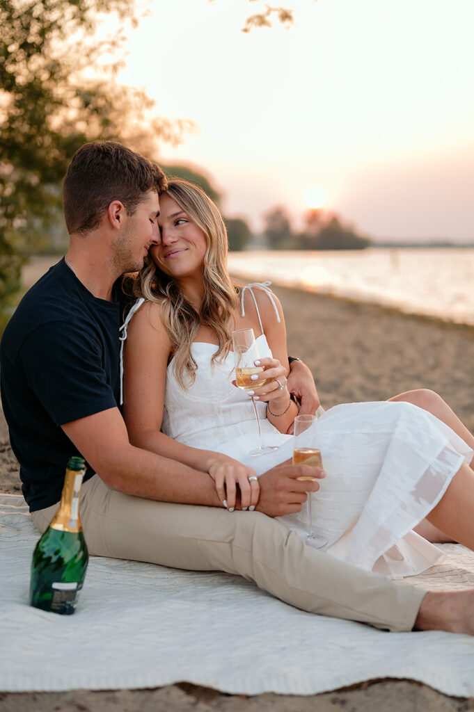 couple being drinking champagne during sunset on Lake Bemidji shore