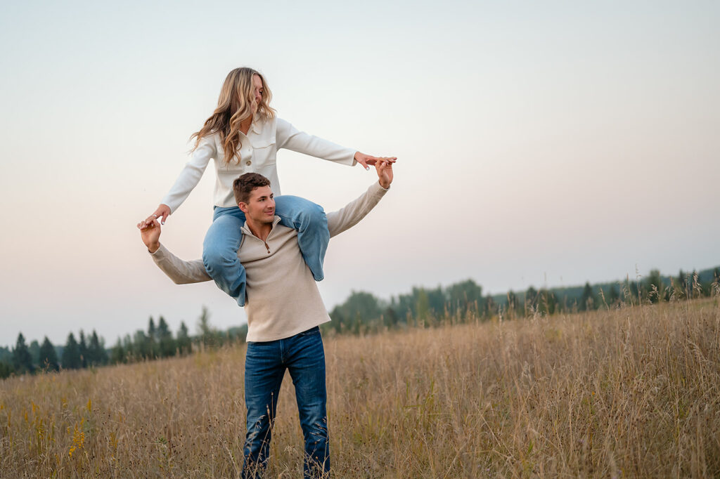 couple being playful during blue hour in a lush golden field