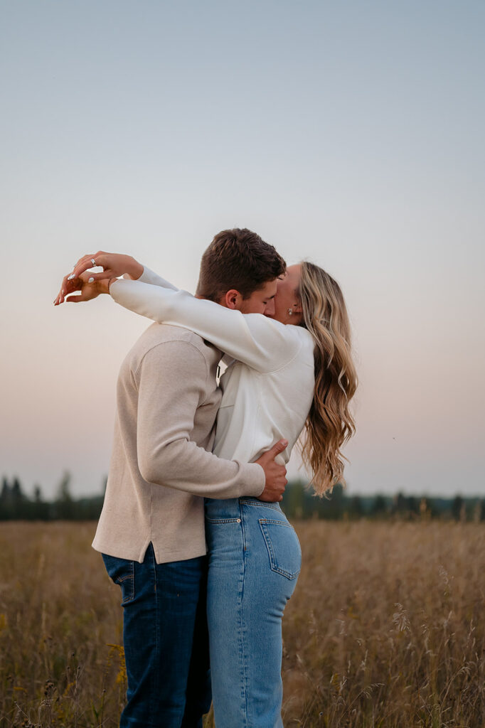 couple being playful during blue hour in a lush golden field