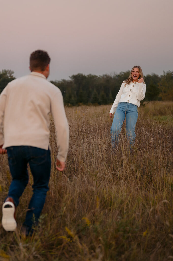 couple being playful during blue hour in a lush golden field