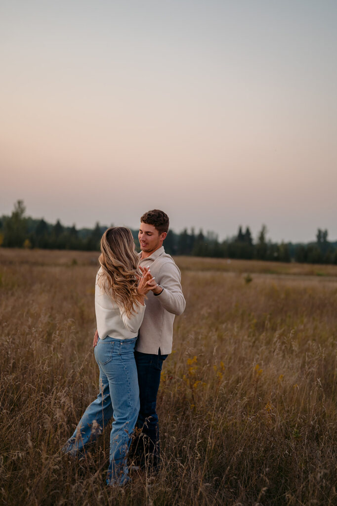 couple being playful during blue hour in a lush golden field