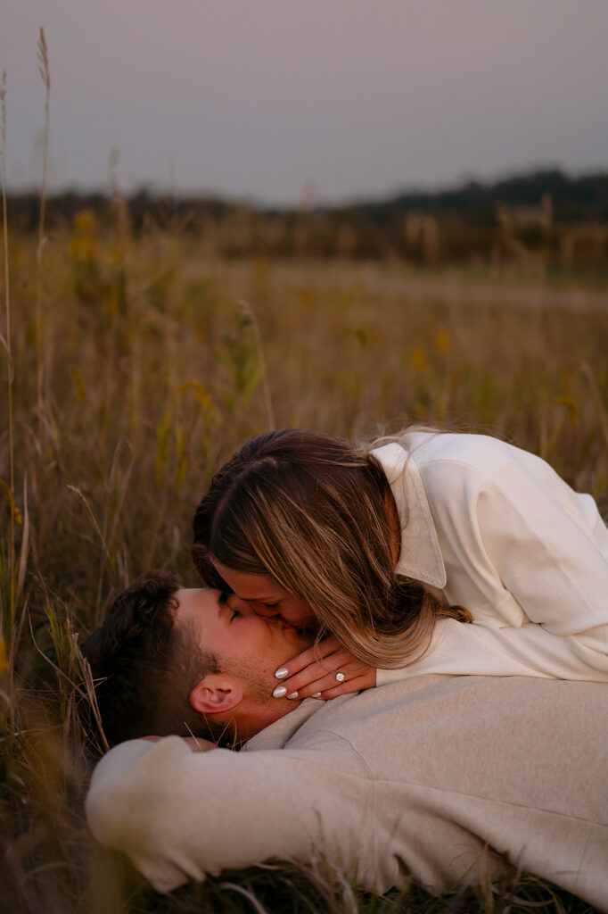 couple laying down together in a lush golden field