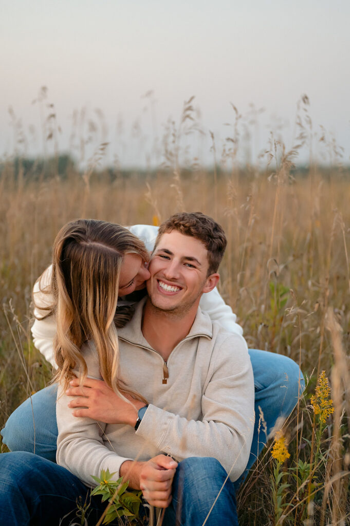 couple sitting down in a lush golden field