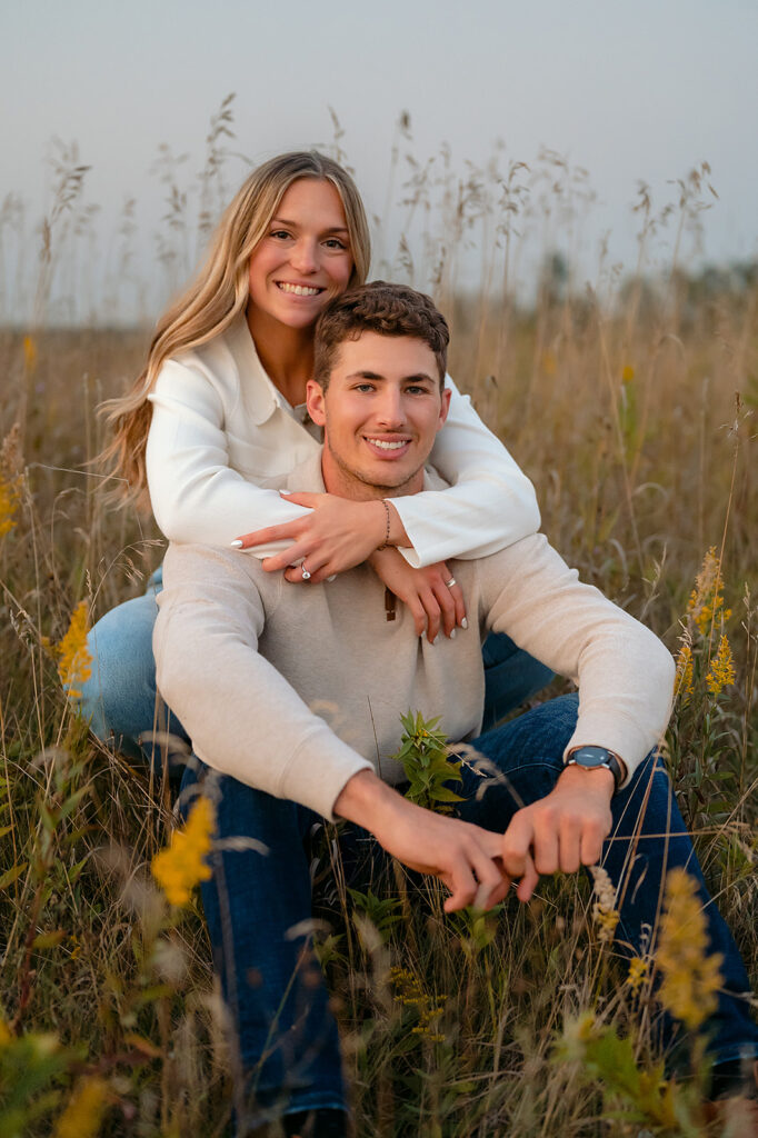 couple sitting down in a lush golden field