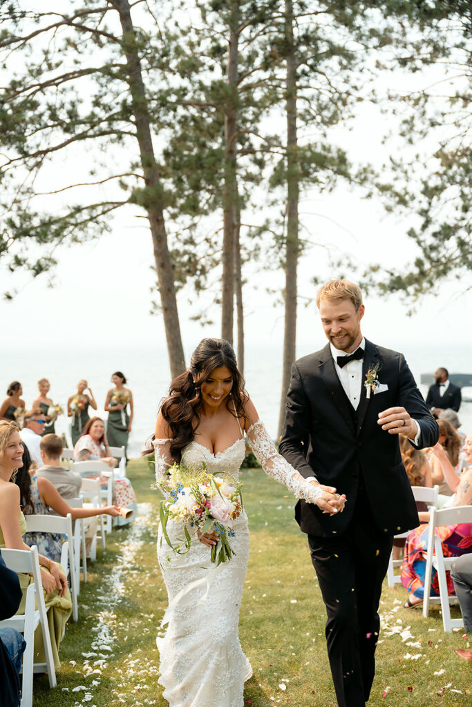 bride and groom ceremony exit after their lakeside wedding ceremony set up overlooking Lake Bemidji