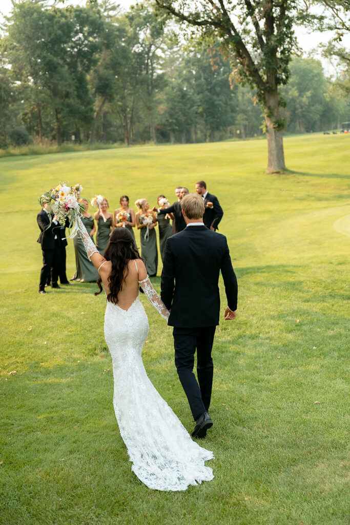 fun bride and groom with their wedding party surrounding them and cheering