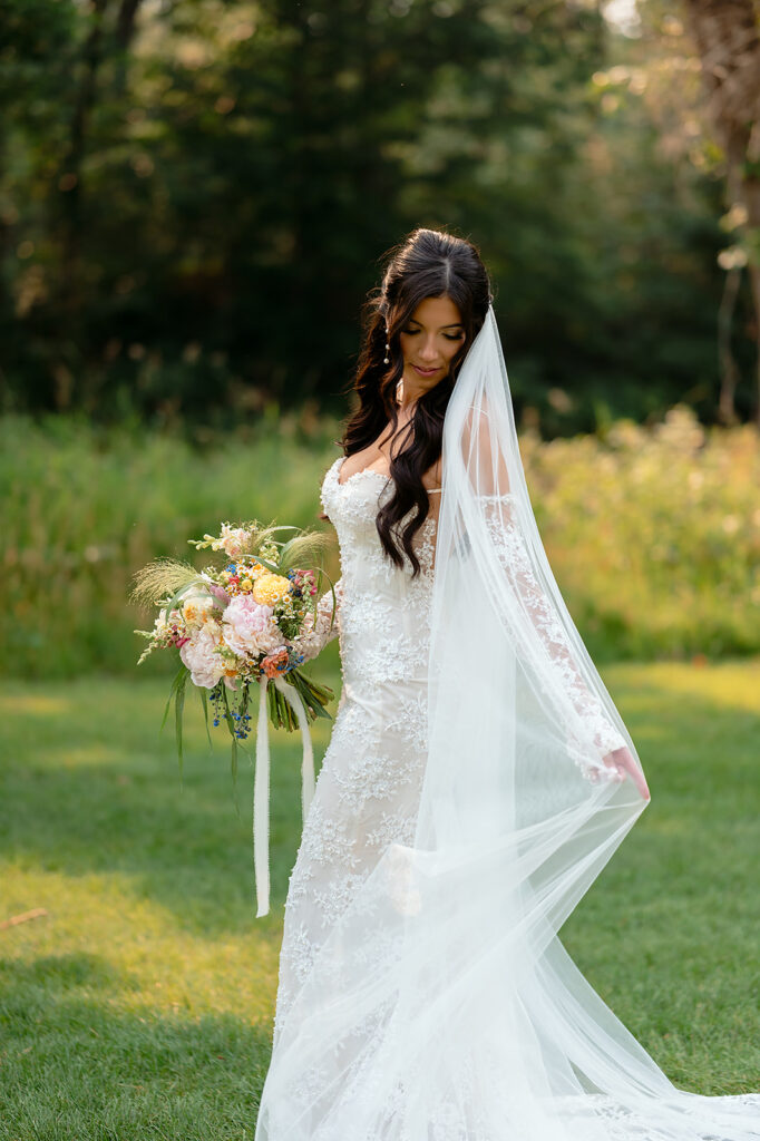 dreamy bride surrounded by lush green landscapes during their lakeside wedding in bemidji mn
