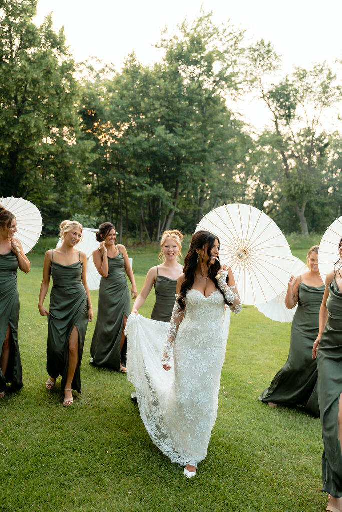 bride and bridesmaids during the summer wedding with parasols
