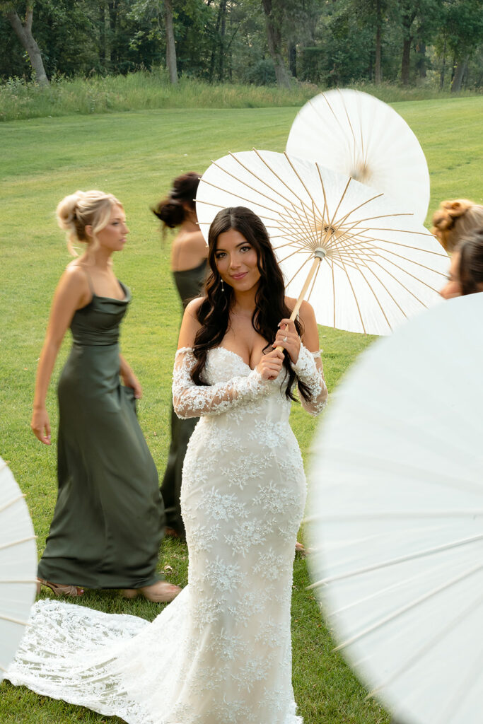 bride and bridesmaids during the summer wedding with parasols