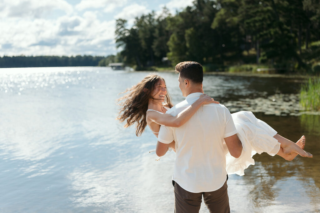 playful couple standing in a lake during their minnesota engagement session