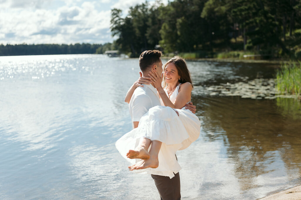 playful couple standing in a lake during their minnesota engagement session