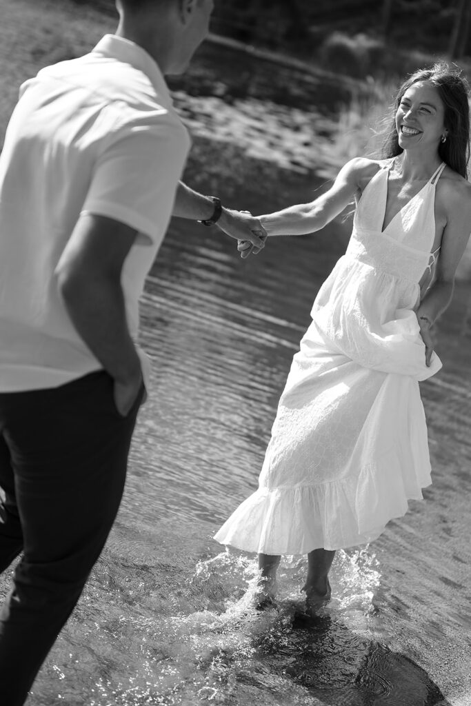 playful couple standing in a lake during their minnesota engagement session