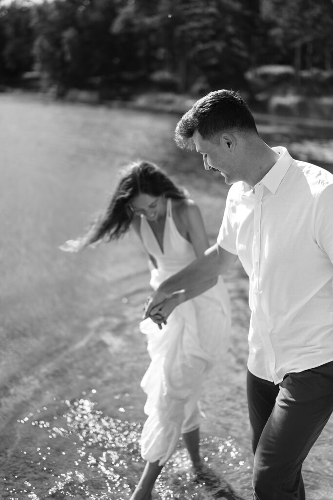 playful couple running in the lake during their romantic Catalyst By Nature Link engagement session