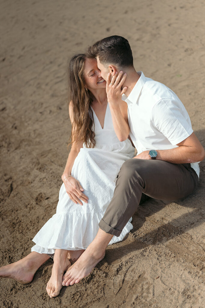 sweet couple sitting on a lake shore