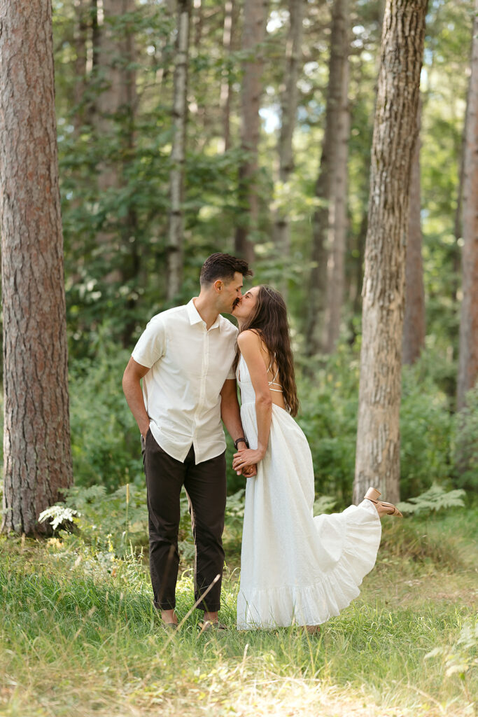 playful couple in a forest during their minnesota engagement session