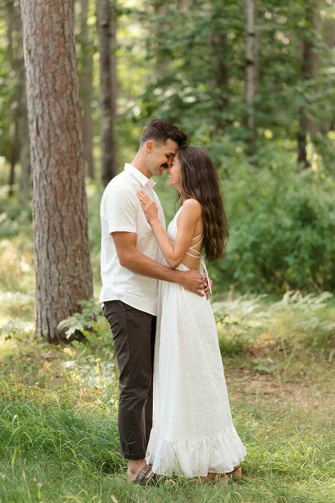 playful couple in a forest during their minnesota engagement session